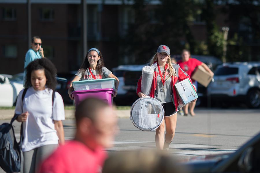 Helpers carrying student's stuff to the dorm